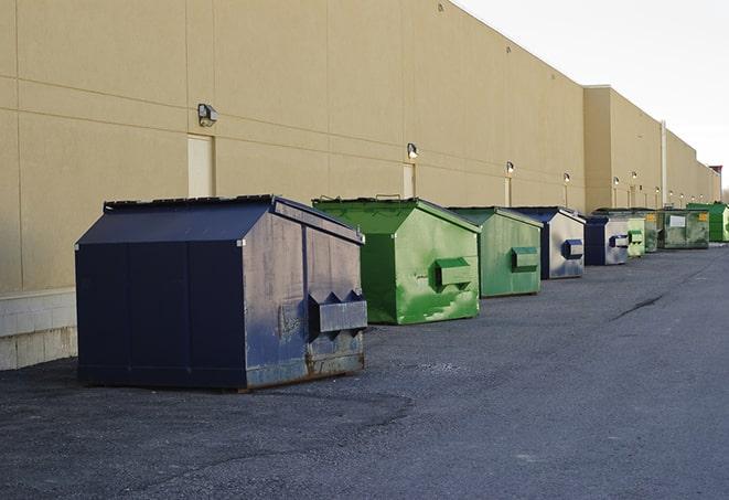 a truck unloading construction waste into a dumpster in Bonita